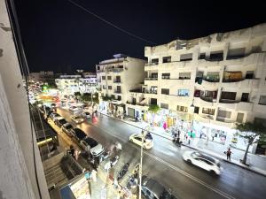 a busy city street at night with cars and buildings at Cozy Ajanif Suite in Martil