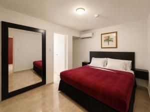 a bedroom with a large bed and a mirror at Ladybugs Apartments in Palm-Eagle Beach