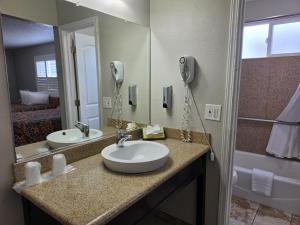 a bathroom with two sinks and a large mirror at San Luis Inn and Suites in San Luis Obispo +26 photos