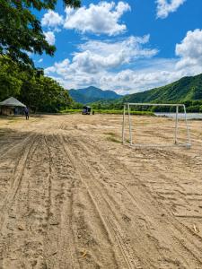 a soccer goal on a dirt road next to a lake at Huiltana ecohotel&resort in Guataquí