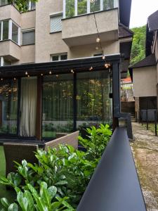 a building with windows and plants in a yard at Drop Kop in Brzeće