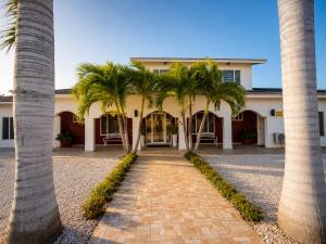 a row of palm trees in front of a building at Ladybugs Apartments in Palm-Eagle Beach