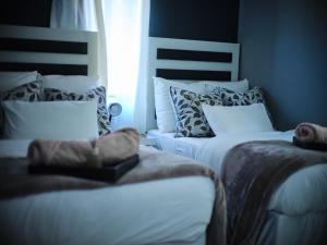 a bedroom with two beds with pillows and a window at P Daisy in Rundu