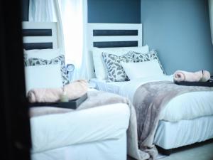 a bedroom with two beds with white sheets and pillows at P Daisy in Rundu