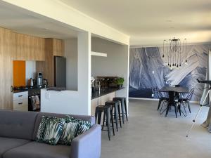 a living room and kitchen with a couch and a table at Black Box Bach in Coopers Beach