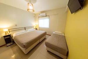 a small bedroom with two beds and a window at Hotel Chardonnay in Tupungato