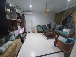 a living room with couches and chairs and a chandelier at Nour 2 in Le Bardo