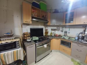 a kitchen with a stove top oven next to a sink at Nour 2 in Le Bardo