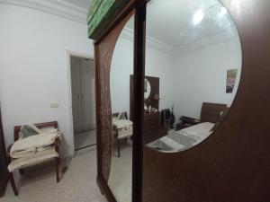 a mirror in a room with two beds and a dressing room at Nour 2 in Le Bardo