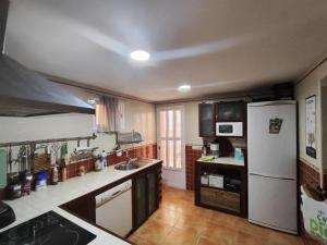 a kitchen with a white refrigerator and a sink at La Casa Azul Bullas in Bullas