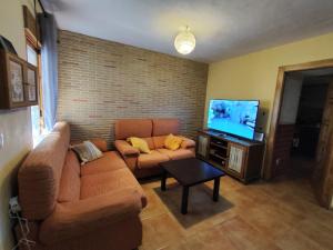 a living room with a couch and a flat screen tv at La Casa Azul Bullas in Bullas
