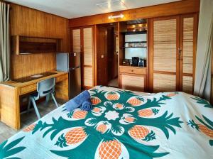 a bedroom with a bed with a pineapple pattern on it at Vahaui Paradis in Avatoru +20 photos