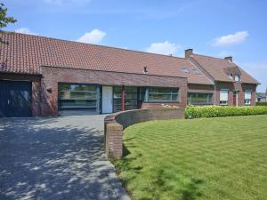 a large brick house with a lawn in front of it at Laurahoeve in Nederweert