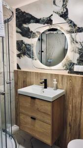 a bathroom with a sink and a mirror at BOOGIE Home Nawrot 13 in Łódź +23 photos