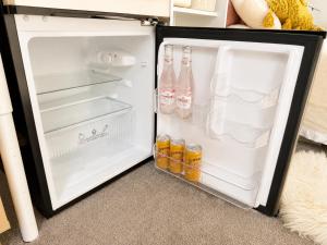 an open refrigerator filled with drinks and bottles of water at Pine Grove Retreat in Auckland