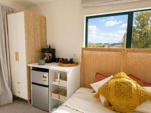 a bedroom with a bed and a large window at Pine Grove Retreat in Auckland
