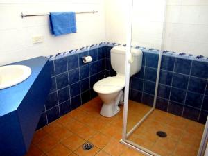 a blue tiled bathroom with a toilet and a sink at Merimbula Coastline Motel in Merimbula +32 photos
