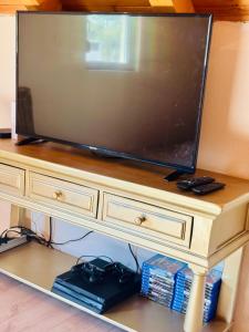 a tv on a wooden stand with a television on it at Villa Silent Bay Lučice in Milna