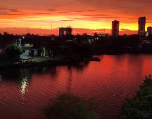 a sunset over a body of water with a city at Casita Verde in Mazatlán