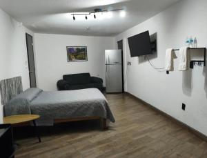 a small room with a bed and a refrigerator at Casita Verde in Mazatlán