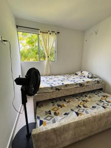 a bedroom with two beds and a window at Aparta Hotel Casacrislaye Santa marta in Santa Marta +15 photos