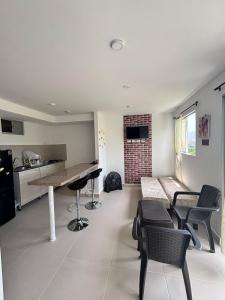 a kitchen and living room with a table and chairs at Aparta Hotel Casacrislaye Santa marta in Santa Marta