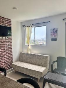 a living room with a couch and a window at Aparta Hotel Casacrislaye Santa marta in Santa Marta