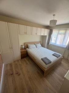 a small bedroom with a bed and two windows at Joni Bungalow-2-Bedroom HOME in Slades Green