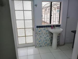 a bathroom with a sink and a window at Gazebo in Port-of-Spain