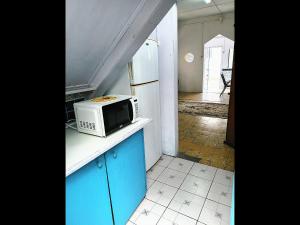 a kitchen with a microwave and a refrigerator at Gazebo in Port-of-Spain +3 photos