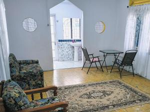 a living room with a couch and a table and chairs at Gazebo in Port-of-Spain