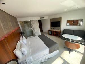 a bedroom with a bed and a couch and a table at Icônico Hotel Nacional in Rio de Janeiro