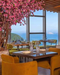 a dining room with tables and chairs and flowers at Icônico Hotel Nacional in Rio de Janeiro +1 photo