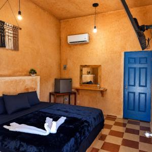 a bedroom with a bed and a blue door at Hotel Hacienda IMI 3 in Imí