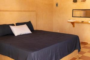 a bedroom with a bed with a white pillow at Hotel Hacienda IMI 3 in Imí