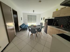 a kitchen with a table and chairs in a room at Petit nid chaleureux in Mimizan