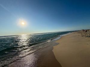 a beach with people walking on the sand and the ocean at Petit nid chaleureux in Mimizan +5 photos