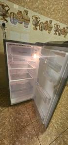an empty refrigerator with its door open in a kitchen at SR Hotel in Salalah