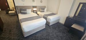 a hotel room with two beds and a television at SR Hotel in Salalah