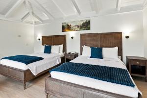 two beds in a room with blue pillows at Carmel Resort Inn in Carmel