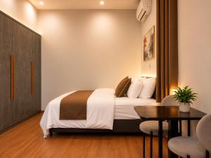 a hotel room with a bed and a table and chairs at Solwind Riverside in Danang +5 photos