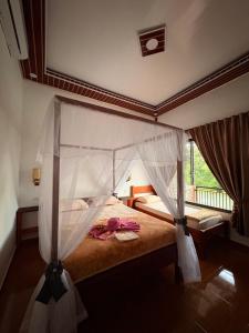 a bedroom with a bed with a canopy at Asim Paris Guesthouse & jungle trekking in Bukit Lawang +73 photos