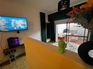 a living room with a tv and a yellow counter at Departamento Las Golondrinas in Estación Coronel Maldonado +6 photos