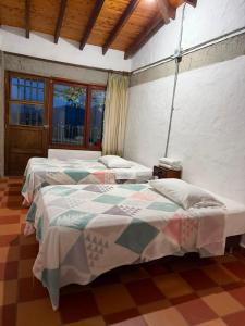 two beds in a room with a room with windows at Villa Palosanto Campestre in Jericó