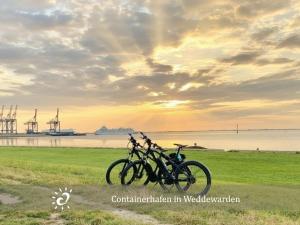 two motorcycles parked in a field near the water at Nordprinz mit Sauna und Whirlpool in Geestland +26 photos