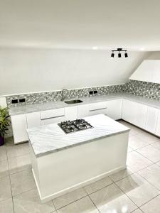 a kitchen with white cabinets and a stove top oven at Dover View Villas in Carriacou