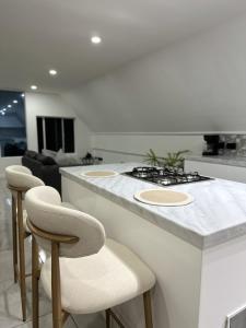 a kitchen with a counter with a stove and stools at Dover View Villas in Carriacou