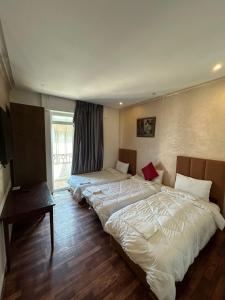 a hotel room with two beds and a window at Hotel Astoria Tanger in Tangier +22 photos