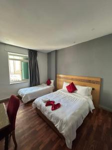 a bedroom with two beds with red bows on them at Hotel Astoria Tanger in Tangier