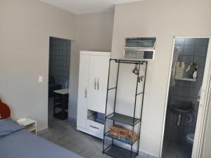 a room with a bathroom with a shower and a shelf at Studio aconchegante perto dos eventos! in Garanhuns
